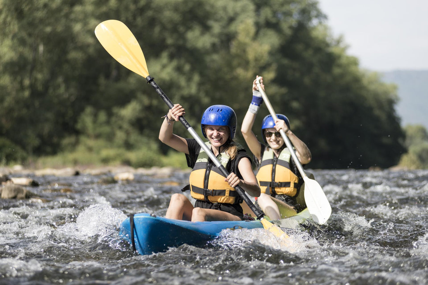 Zwei lachende Studenten beim Kanu fahren auf einem reißenden FLuss im Ardèche Action Camp – APACAMPA Reisen
