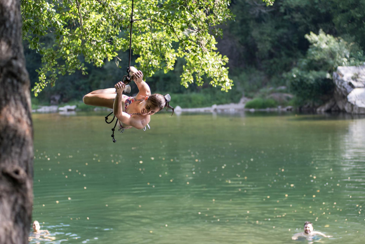 Junge Frau beim Klippenspringen mit Affenschaukel über einem ruhigen See, Natur pur im Ardèche Action Camp – APACAMPA Reisen