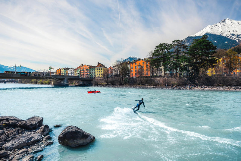 Wakeboarder vor den Toren von Innsbruck vor der bergigen Kulisse Österreichs im Innsbruck Up Stream Surfcamp – APACAMPA Reisen