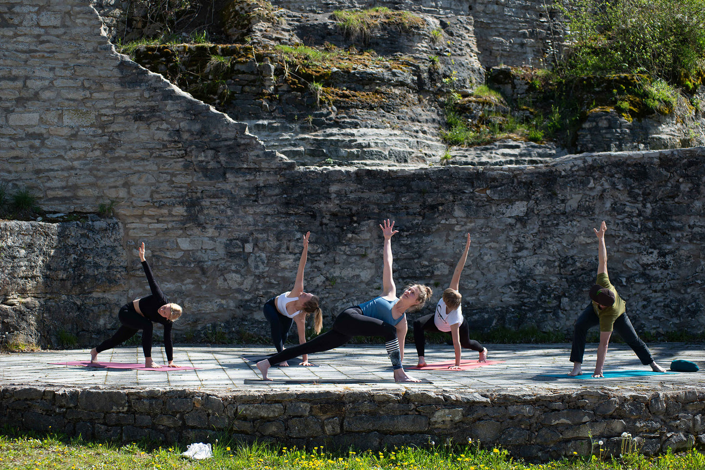 Fünf Frauen beim Yogatraining der Figur "gedrehtes Dreieck"während einer Gruppenreise im Ardèche Yoga Camp – APACAMPA Reisen