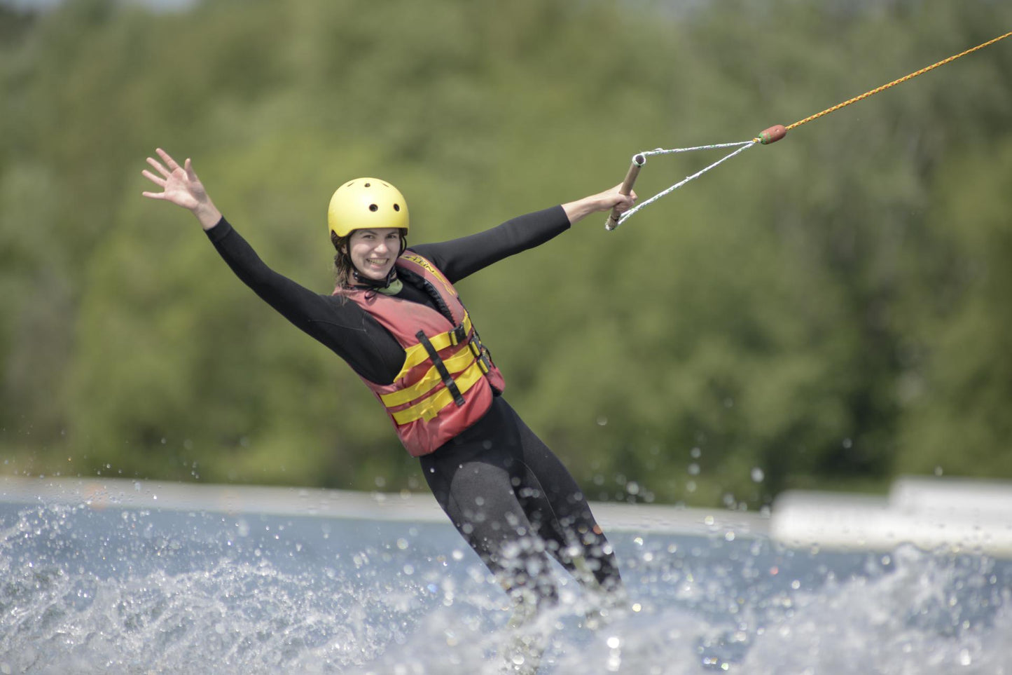 Erfahrene Wasserski-Fahrerin in eleganter Pose auf einem bayrischen See im Wakeboard Camp – APACAMPA Reisen