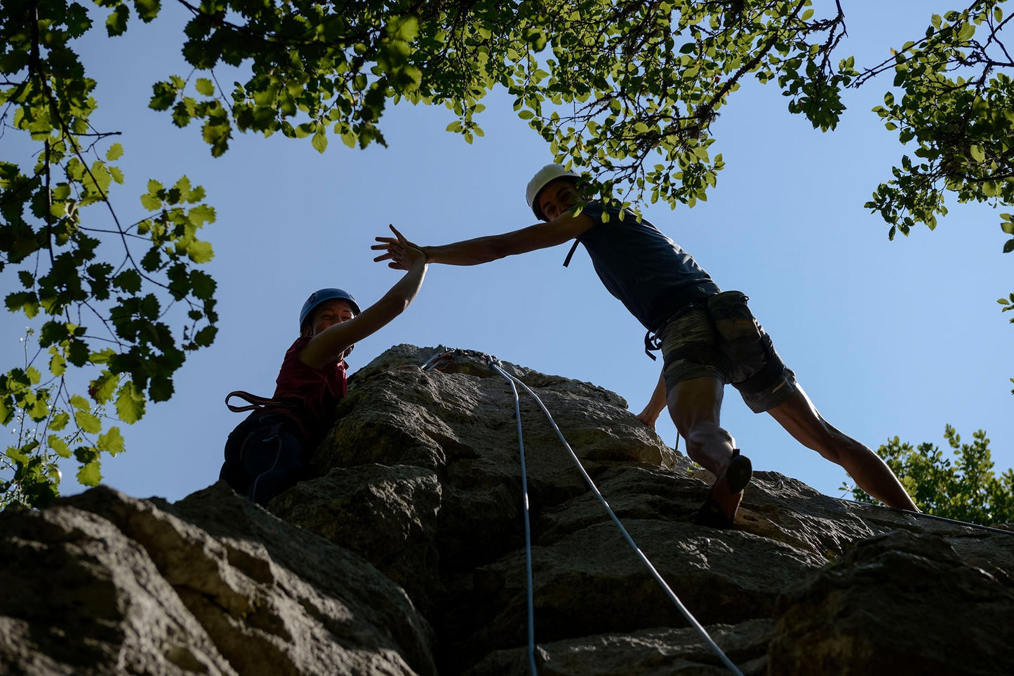 Zwei Kletterer beglückwünschen sich zum erfolgreichen Aufstieg an einer Kletterwand im Süden Frankreichs – APACAMPA Reisen